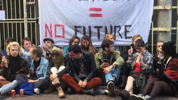 Sit-in
Ook aan de voorkant van het P.C. Hoofthuis is nu een sit-in gestart. Deelnemers lezen studieboeken, drinken blikjes bier, roken sigaretten en zingen de bekende leuzen.&nbsp;&lsquo;H&eacute; ho CvB, hier krijg je problemen mee.&rsquo;