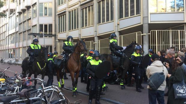 Ontruiming begint
In de Spuistraat lijkt de ontruiming nu echt te beginnen. Studenten die voor de deur zitten vertrekken,&nbsp;de studenten die blijven zijn omsingeld en zingen &lsquo;peaceful protest&rsquo;.