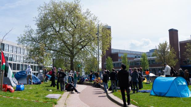 Tenten en barricadesDe eerste studenten arriveerden rond het middaguur op het veldje bij Roeterseiland, in de volksmond ook wel Roetersweiland genoemd. Er werden tenten opgezet en de twee bruggen werden gebarricadeerd met grote pallets. Toegang is nog wel mogelijk vanaf de andere kant.&nbsp;De demonstranten eisen dat de UvA transparant is over de banden met Isra&euml;lische instituties en bedrijven, inclusief onderwijsinstellingen. Daarnaast willen ze dat de UvA alle banden verbreekt met zowel Isra&euml;lische bedrijven als Isra&euml;lische instituties. &nbsp;Ook willen de demonstranten dat de UvA zich uitspreekt over de situatie in Gaza. &lsquo;Al zeven maanden zijn we getuige van een genocide in Gaza,&rsquo; zegt een van de demonstranten. &lsquo;En zeven maanden lang hebben de universiteiten gedaan alsof ze neutraal waren en niets gedaan hebben. Daarom kiezen we nu bewust voor escalatie.&rsquo;
&nbsp;
Lees hier verder.&nbsp;