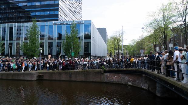 Toespraken
Er worden speeches gegeven op de Roetersstraat, die inmiddels is afgezet door de politie uit veiligheidsoverwegingen. De sprekers vatten de gebeurtenissen van gisteravond samen en hekelen het gewelddadige optreden van de politie. &nbsp;&lsquo;We moeten als gehele academische community, studenten, hoogleraren en andere medewerkers, niet accepteren dat de universiteit politie toelaat op campus en onze mensenrechten in het gedrang brengt,&rsquo; aldus een van de sprekers. &nbsp;In de menigte zijn spandoeken te zien, beschreven bordjes en Palestijnse vlaggen. Ook bioscoop Kriterion heeft de Palestijnse vlag uitgehangen.