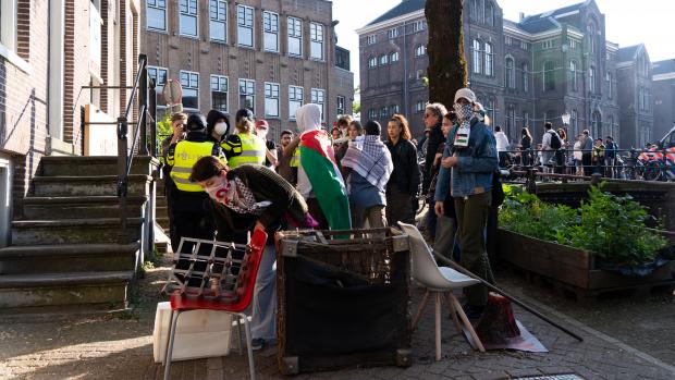 Barricades
Zeker 250 demonstranten zijn bezig om het gebied rondom de voormalige Academische Club, die zij nu zeggen bezet te hebben, te barricaderen. Daarvoor halen ze materiaal van de bouwplaats van de nieuwe UB.
&nbsp;
UvA-medewerker Paul Koopman, lid van de Ondernemingsraad van de Faculteit der Geesteswetenschappen, komt uit een vergadering waar hij te horen heeft gekregen dat de Centrale Ondernemingsraad van de UvA morgenochtend met een oproep zal komen aan het bestuur van de UvA om geen politie op de universiteit in te zetten. &lsquo;Geen geweld op de UvA&rsquo;, stelt Koopman ook.