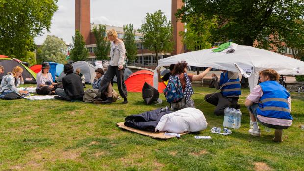  Onderhandelingen vandaag afgerondDe onderhandelingen&nbsp;tussen de&nbsp;demonstranten en het CvB zijn&nbsp;voor vandaag&nbsp;afgelopen. Het UvA-bestuur&nbsp;en de&nbsp;demonstranten&nbsp;zijn het&nbsp;nog niet eens&nbsp;met elkaar over het al dan niet verbreken van&nbsp;samenwerkingen&nbsp;van de UvA&nbsp;met Isra&euml;lische instellingen. De organisatie van de bezetting spreekt de hoop uit morgen verder te spreken over&nbsp;de&nbsp;eisen&nbsp;van de demonstranten: het verbreken van alle banden. Een antwoord van de UvA volgt &lsquo;binnen een uur&rsquo;, volgens een onderhandelaar via een megafoon op het Roeterseiland.&nbsp;&lsquo;Het UvA-bestuur en de decanen lagen niet allemaal op &eacute;&eacute;n lijn en dat biedt perspectief&rsquo;, laat de onderhandelaar ten slotte weten. De UvA erkent dat er verschillend wordt gedacht, &lsquo;maar dat is niet gek&rsquo;, zegt een woordvoerder. &lsquo;Iedereen is het erover eens dat wat in Gaza gebeurt, gruwelijk is en de spuigaten uitloopt. Er is inmiddels voldoende bewijs om van genocide te spreken. De vraag is nu alleen, hoe ga je met deze feiten om en wat is de rol van de universiteit daarin?&rsquo;&nbsp;&lsquo;Er is een groep op de universiteit die vindt dat alle banden verbroken moeten worden met Isra&euml;l,&rsquo; aldus de woordvoerder. &lsquo;Een andere groep zegt juist:&nbsp;zo straf je ook de mensen die kritisch zijn op Netanyahu. Je moet juist de politieke druk verhogen en dat doe je door ook met de mensen daar in gesprek te blijven.&rsquo;&nbsp;&nbsp;Al verlopenDe onderhandelaar&nbsp;van de demonstranten&nbsp;laat tot slot aan de mensen in het kamp weten dat de Faculteit der Geesteswetenschappen de samenwerking met Ben-Gurion Universiteit in Be&euml;r Sjeva niet gaat verlengen. Maar volgens de UvA was deze samenwerking in 2023 al verlopen en werd deze niet verlengd. &lsquo;En er is momenteel, gezien de situatie daar, ook niet de intentie om deze samenwerking te verlengen,&rsquo; aldus de UvA-woordvoerder.&nbsp;&nbsp;Mogen de demonstranten ook vannacht nog blijven? Volgens de UvA is er geen reden om aangifte te doen als&nbsp;de bezetting van het &lsquo;weiland&rsquo;&nbsp;zo vreedzaam blijft verlopen. &lsquo;De situatie is ook enigszins veranderd. Het OM heeft gezegd dat dit gebied op Roeterseiland publiekelijk toegankelijk is, dus er kan geen sprake zijn van erfvredebreuk. Het is dan ook aan de driehoek om deze aangifte eventueel te doen.&rsquo; Er zijn andere gronden waarop de UvA aangifte zou kunnen doen, maar die zijn nu niet aan de orde. &lsquo;Mensen zijn niet gemaskerd, er zijn geen barricades en de demonstratie verloopt vreedzaam.&rsquo;&nbsp;&nbsp;